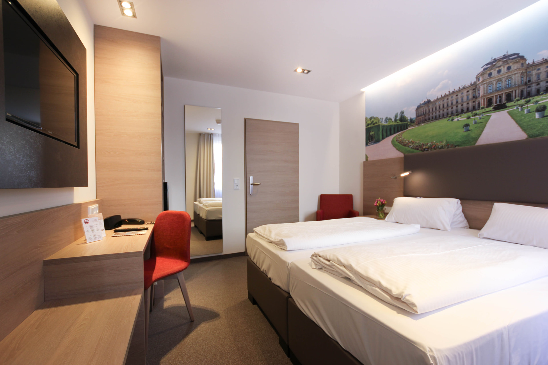 Classic-Doppelzimmer mit Schreibtisch und rotem Stuhl im City Hotel Würzburg
